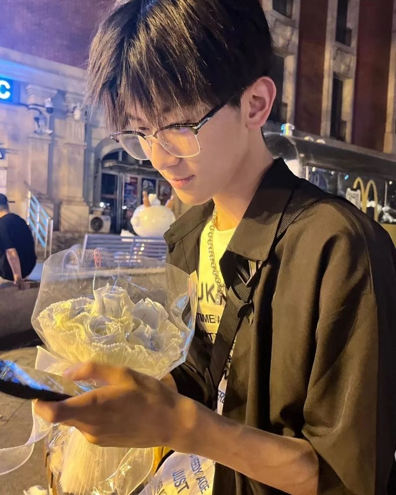 ảnh trai đẹp đeo kính cầm hoa